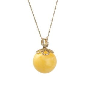 Złota unikatowa zawieszka bursztynowa w kształcie kulki ozdobiona lśniącymi cyrkoniami